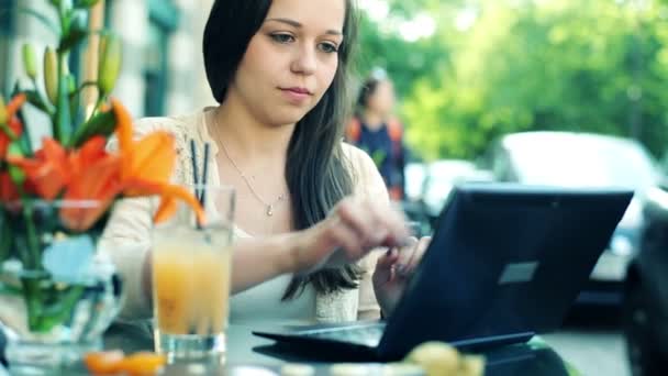 在咖啡馆里的笔记本电脑上打字的女人 — 图库视频影像
