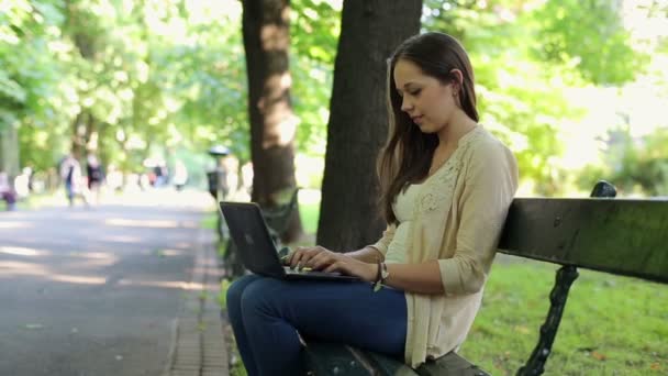 Woman working on laptop in park — Stock Video