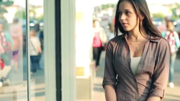 Женщина смотрит на витрину магазина в городе — стоковое видео