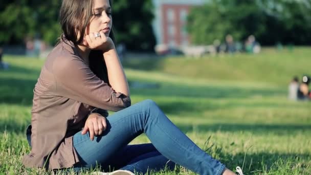 Triste femme assise sur l'herbe — Video