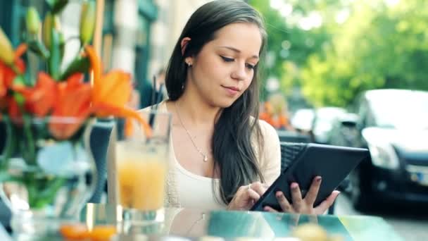 Mujer con Tablet PC sentado en la cafetería — Vídeo de stock