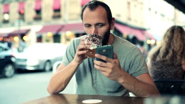 Man texting on smartphone and drinking beer — Stock Video