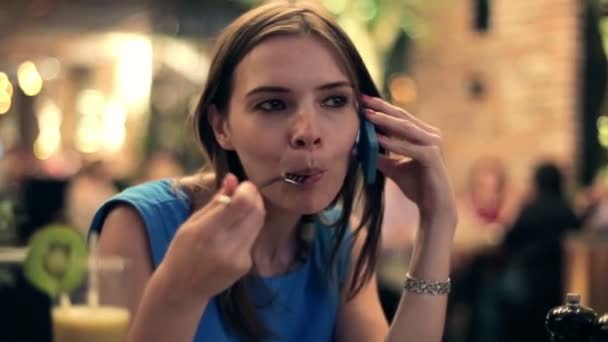 Mujer hablando por celular y comiendo comida — Vídeos de Stock