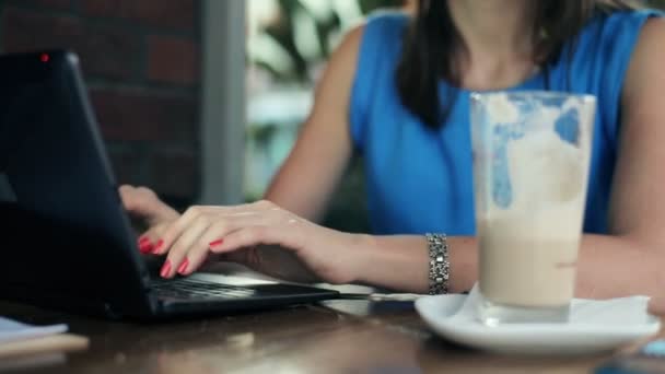 Handen typen op laptop in café — Stockvideo