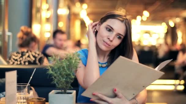 Menú de lectura mujer en restaurante — Vídeos de Stock