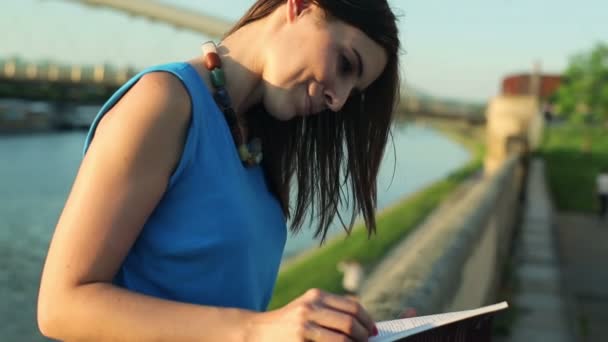 Vrouw lezen boek door de rivier — Stockvideo