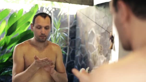 Man schoonheid room toe te passen op zijn gezicht — Stockvideo