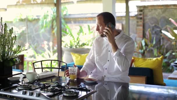 Hombre hablando por celular y bebiendo jugo — Vídeo de stock