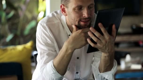 Man met tablet computer thuis — Stockvideo