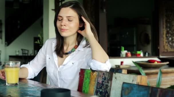 Mujer bebiendo jugo junto a la mesa — Vídeos de Stock