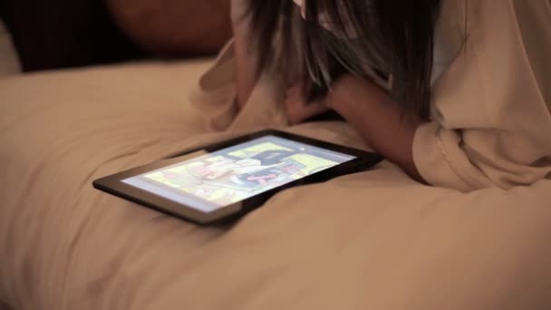 Mulher assistindo fotos no tablet deitado na cama — Vídeo de Stock