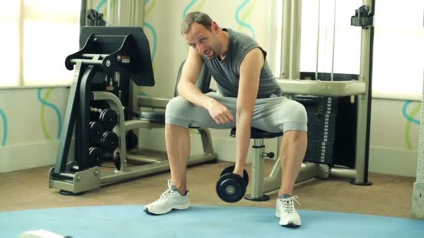 Uomo che si allena con i manubri in palestra — Video Stock