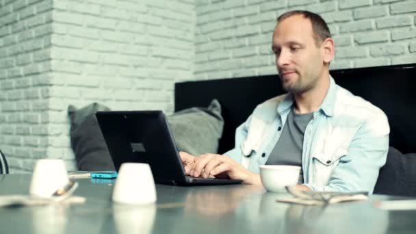 Man med laptop sitter i café — Stockvideo