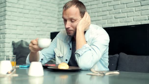 Λυπημένος άνθρωπος τρώει φρούτα στο café — Αρχείο Βίντεο