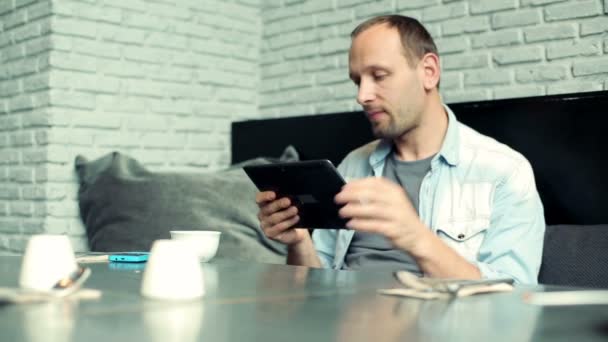 Mann med tablett drikke kaffe på kafe – stockvideo