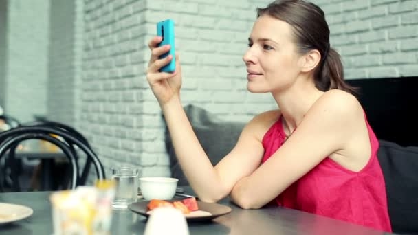 Женщина отправляет смс на смартфон в кафе — стоковое видео
