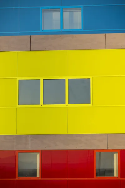 อาคารสํานักงานสมัยใหม่ อาคารที่มีสีสันในสถานที่อุตสาหกรรม หน้าต่างสีเหลือง สีฟ้า และสีแดง . — ภาพถ่ายสต็อก