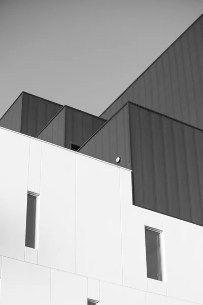 Μοντέρνα κτίρια. πολύχρωμα κτίρια σε βιομηχανικό χώρο. κάθετη μορφή και ασπρόμαυρη εικόνα. — Φωτογραφία Αρχείου