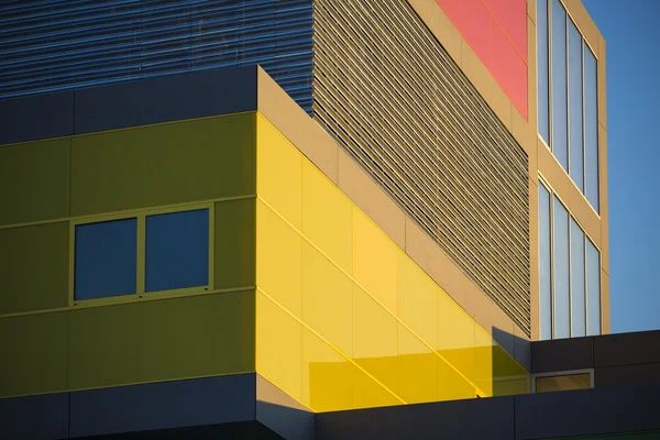 Ufficio moderno edifici whit rosso e giallo windows. edifici colorati in un luogo industriale con cielo blu. — Φωτογραφία Αρχείου