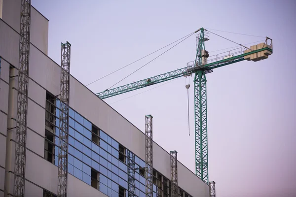 Cantiere con gru con cielo viola al tramonto . — Foto Stock