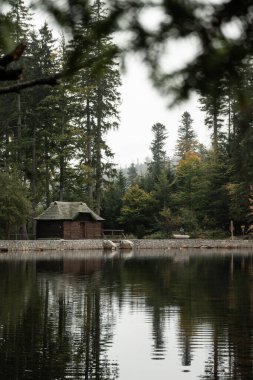 A small wooden cabin and Black lake at Sumava national park