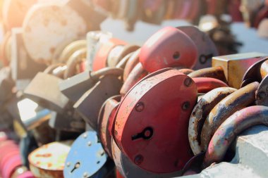 Aşk ve bağlılığın sembolü olarak, güneş ışığında köprünün korkuluğunda kalp şeklinde düğün kilitleri.