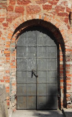 Tuğla duvardaki ortaçağ metal kapısı