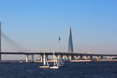 Asma köprüye ve gökdelene karşı yelken açan yatlar..