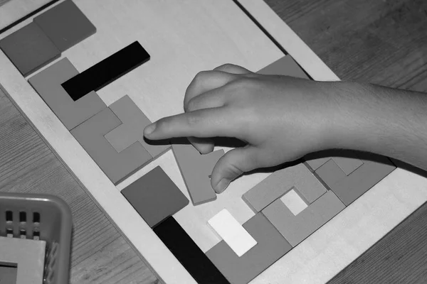 아이는 교육용 게임을 하면서 모양의 기하학적 형태의 퍼즐을 만든다 — 스톡 사진