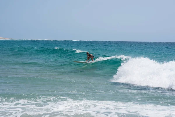 Donna vista cavalcare onda con la sua tavola da surf — Foto Stock