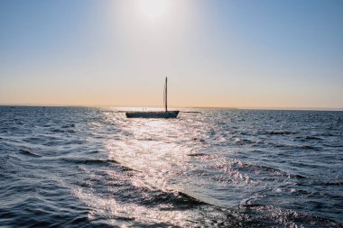 Uzaktaki insanlarla birlikte suda görülen yemek teknesi.