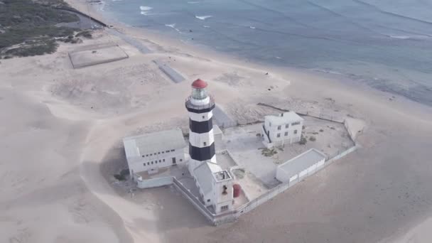 Drone mengorbit di sekitar mercusuar dengan laut di latar belakang — Stok Video
