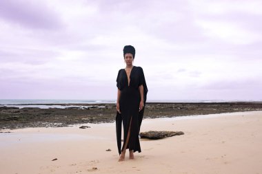 Sahilde duran şık bir kadının portresi.