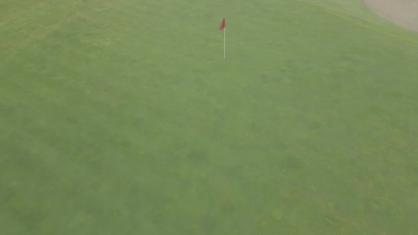 Drone vliegt weg van rode vlag op de golfbaan — Stockvideo