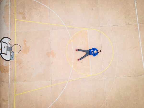 Légi felvétel az emberről, amint a kosárlabdapálya szabad dobóvonalán fekszik — Stock Fotó