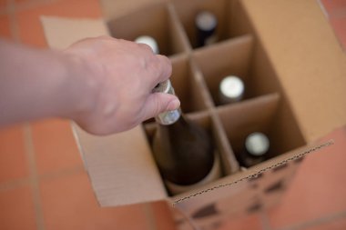 Hand seen removing wine bottle from box
