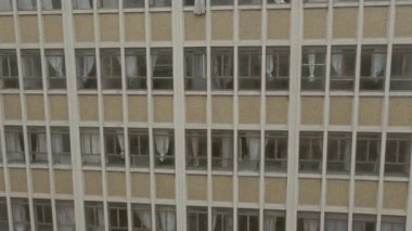 Drone descending past grunge looking windows