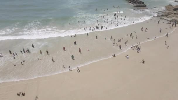 Drone flying over coastline with people seen swimming — Stok Video