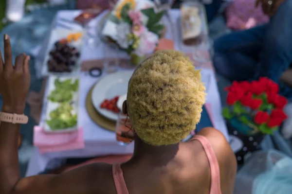 Rückansicht einer Frau mit buntem Haar, die draußen sitzt — Stockfoto
