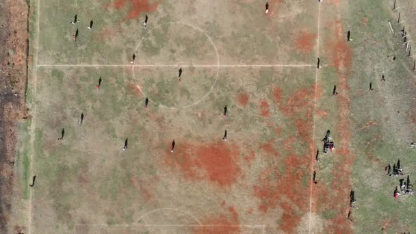 Вид с воздуха на грубое футбольное поле с игроками — стоковое видео