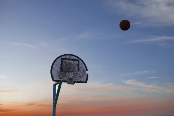 Basketbal in de lucht op weg naar hoepel — Stockfoto