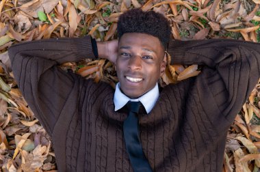 Düşen yapraklara uzanan yakışıklı adam.