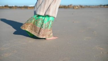 Woman seen walking along empty beach
