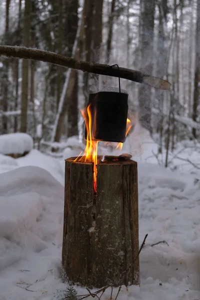 Il bollitore è riscaldato su un fuoco. Candela finlandese. il concetto di relax nella foresta in inverno — Foto Stock