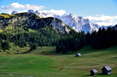 Prato Piazza çayırları, öğleden sonra güneşinin son ışıklarıyla ışıl ışıl parlıyordu. Arka planda Cristallo grubunun muazzam kalabalığı vardı.