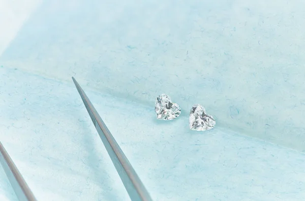 Paar Heart Shaped Diamonds Blauwe Achtergrond Met Pincet — Stockfoto