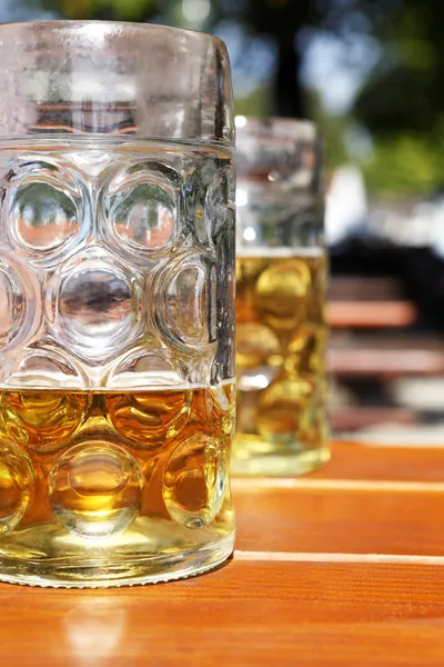 Mitad taza de cerveza llena en el jardín de cerveza —  Fotos de Stock