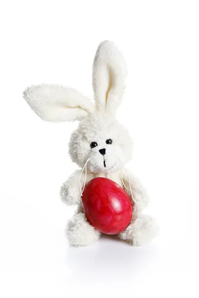 Stuffed easter bunny with red egg — Stock Photo, Image