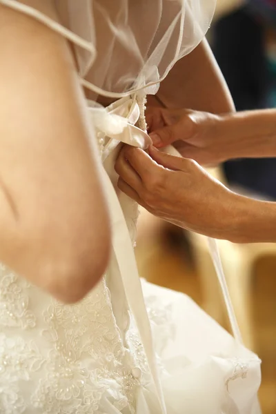 Невеста при затягивании платья — стоковое фото