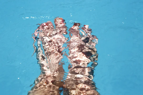 Splashing female feet in a swimming pool — Stock Photo, Image